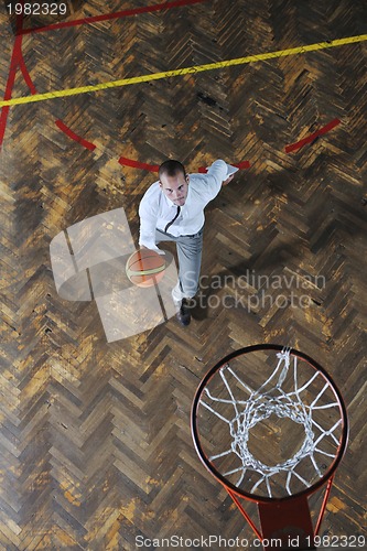 Image of businessman holding basketball ball