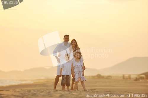 Image of happy young family have fun on beach at sunset