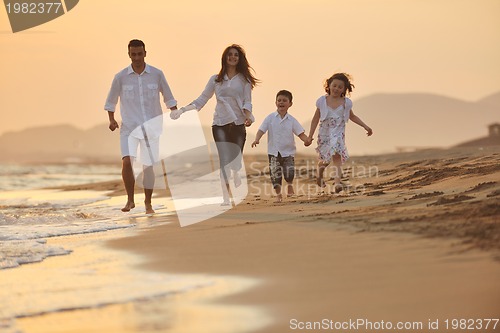 Image of happy young family have fun on beach at sunset