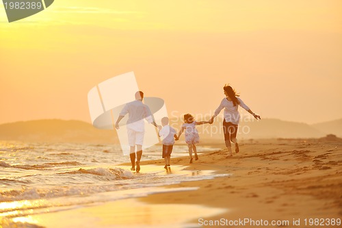 Image of happy young family have fun on beach at sunset
