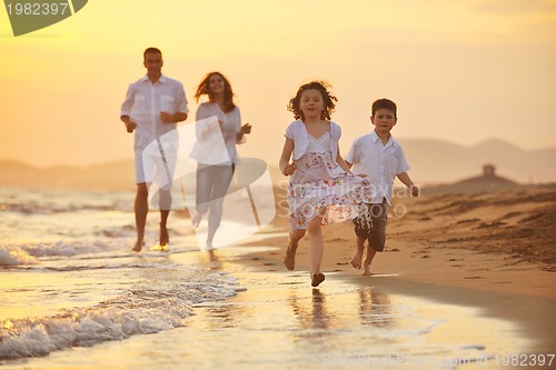Image of happy young family have fun on beach at sunset