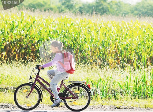 Image of schoolgirl traveling to school on bicycle