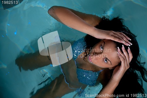 Image of pretty young lady  relaxing in the swimming pool