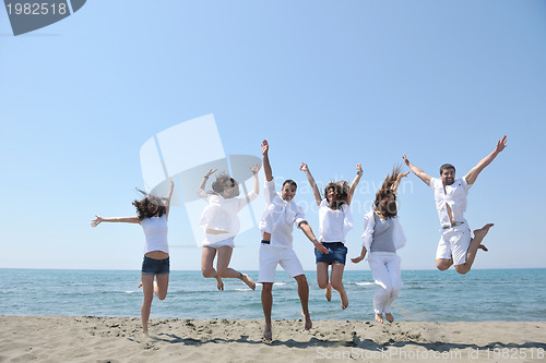Image of happy people group have fun and running on beach