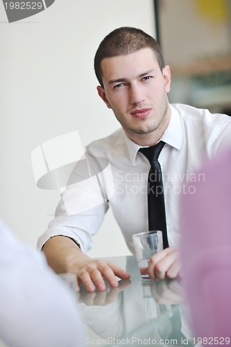 Image of young business man alone in conference room