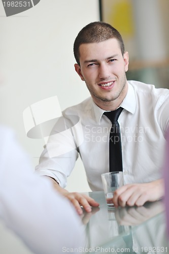 Image of young business man alone in conference room