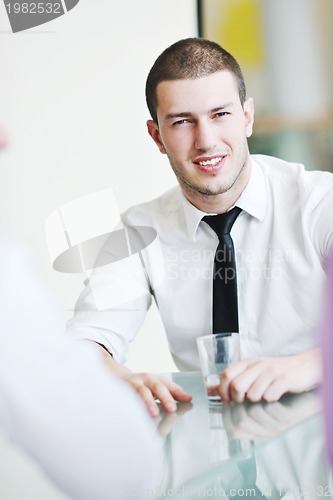 Image of young business man alone in conference room