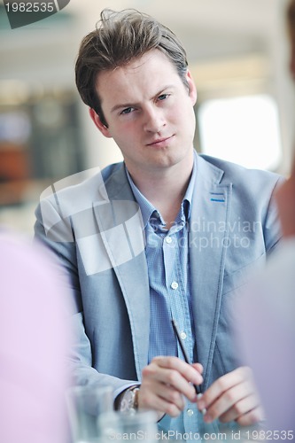 Image of young business man alone in conference room