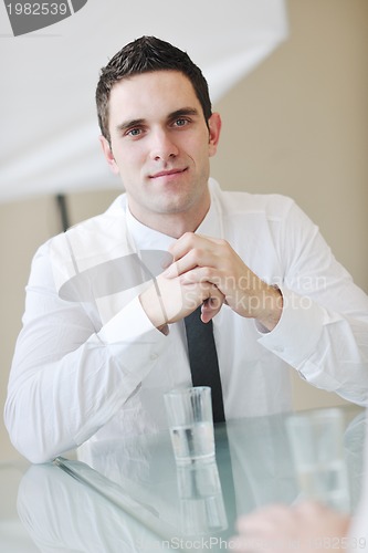 Image of young business man alone in conference room