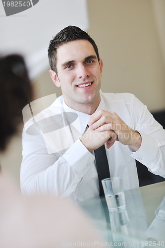 Image of young business man alone in conference room