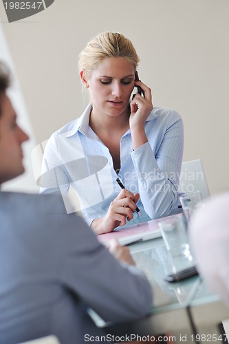 Image of young business woman talk by cellphone on meetng