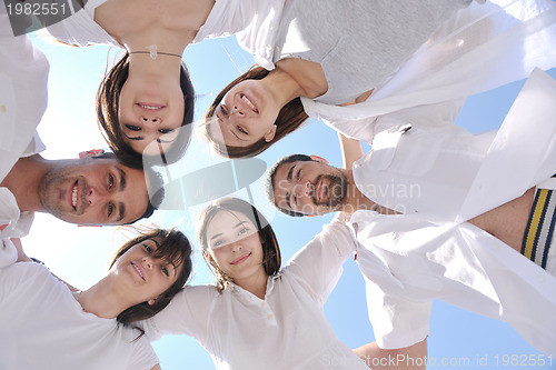 Image of Group of happy young people in circle at beach