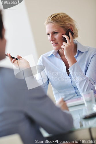 Image of young business woman talk by cellphone on meetng