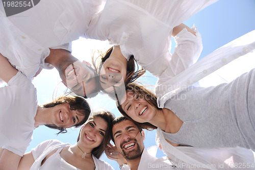 Image of Group of happy young people in circle at beach