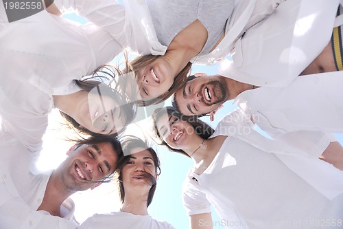 Image of Group of happy young people in circle at beach