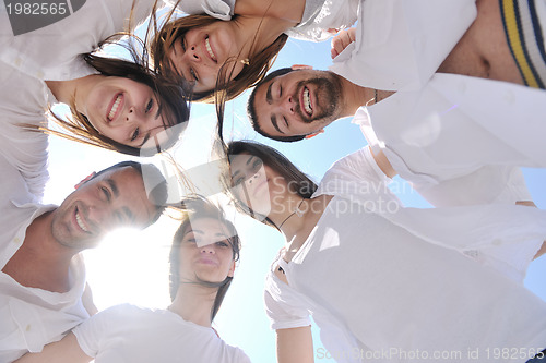 Image of Group of happy young people in circle at beach