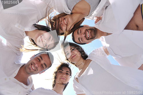 Image of Group of happy young people in circle at beach