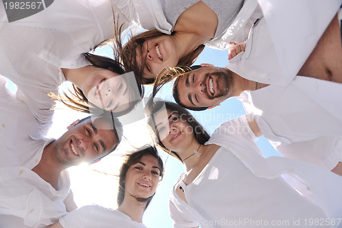 Image of Group of happy young people in circle at beach