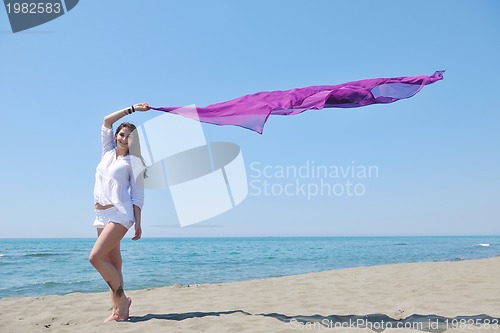 Image of beautiful young woman on beach with scarf