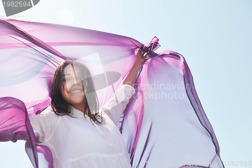 Image of beautiful young woman on beach with scarf