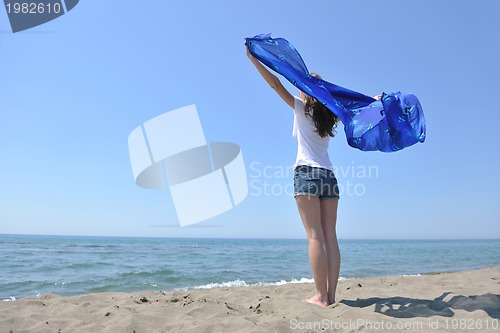 Image of beautiful young woman on beach with scarf