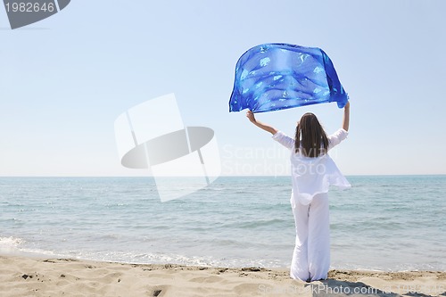 Image of beautiful young woman on beach with scarf