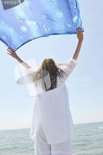 Image of beautiful young woman on beach with scarf