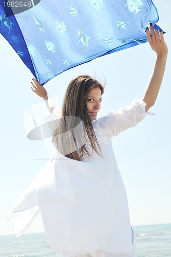 Image of beautiful young woman on beach with scarf