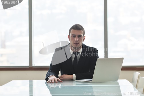 Image of young business man alone in conference room