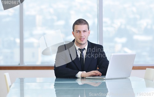 Image of young business man alone in conference room
