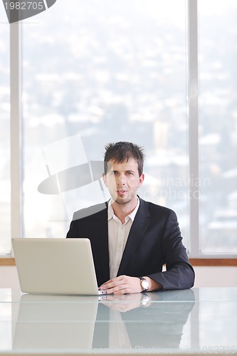 Image of young business man alone in conference room
