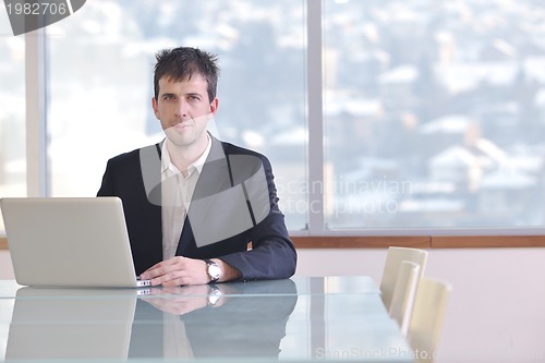 Image of young business man alone in conference room