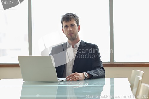Image of young business man alone in conference room