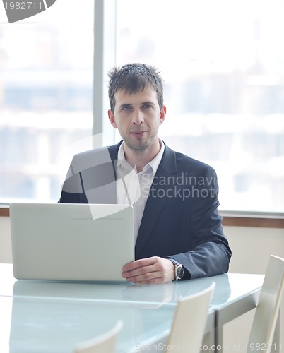 Image of young business man alone in conference room