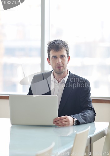 Image of young business man alone in conference room