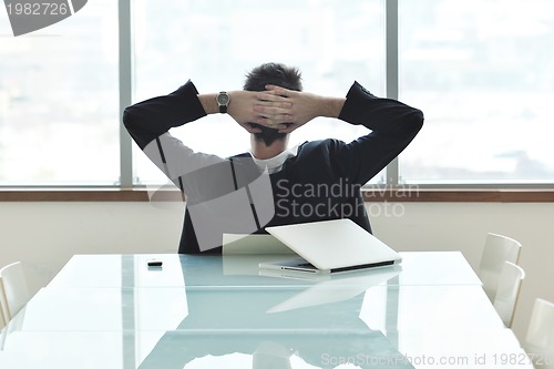 Image of young business man alone in conference room
