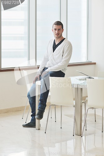Image of young business man alone in conference room