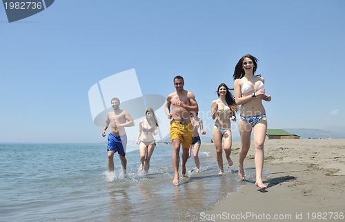 Image of happy people group have fun and running on beach