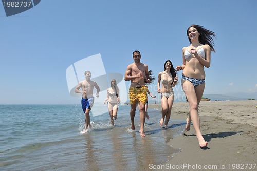 Image of happy people group have fun and running on beach