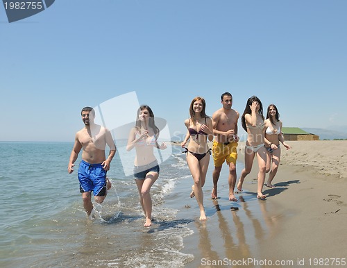 Image of happy people group have fun and running on beach