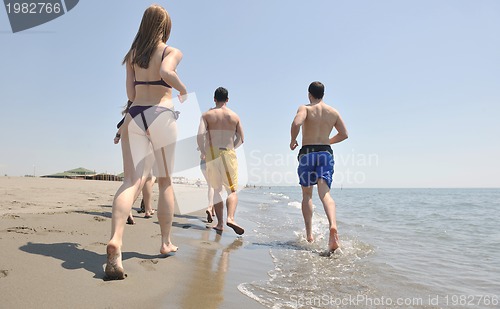 Image of happy people group have fun and running on beach