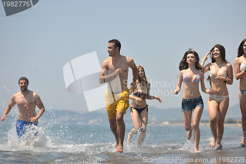 Image of happy people group have fun and running on beach