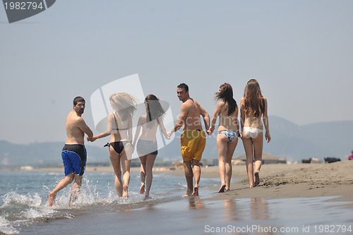 Image of happy people group have fun and running on beach