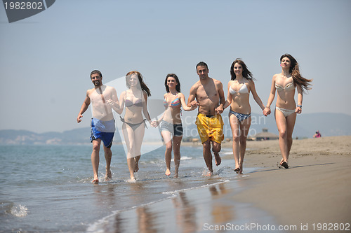 Image of happy people group have fun and running on beach