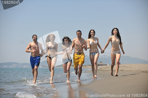 Image of happy people group have fun and running on beach
