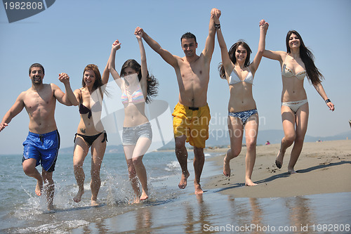 Image of happy people group have fun and running on beach