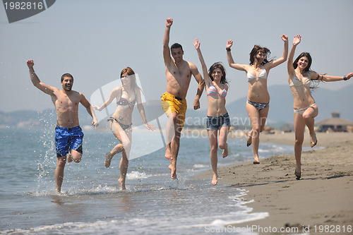 Image of happy people group have fun and running on beach