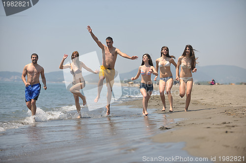 Image of happy people group have fun and running on beach