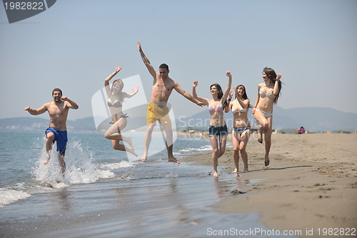 Image of happy people group have fun and running on beach