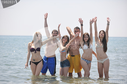 Image of happy people group have fun and running on beach